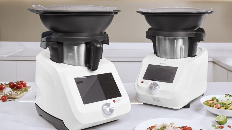 Zwei Monsieur Cuisine stehen auf einem weißen Tisch. Auf beiden kommt der Garkorb zum Einsatz. Zwei Monsieur Cuisine stehen auf einem weißen Tisch. Auf beiden kommt der Garkorb zum Einsatz.