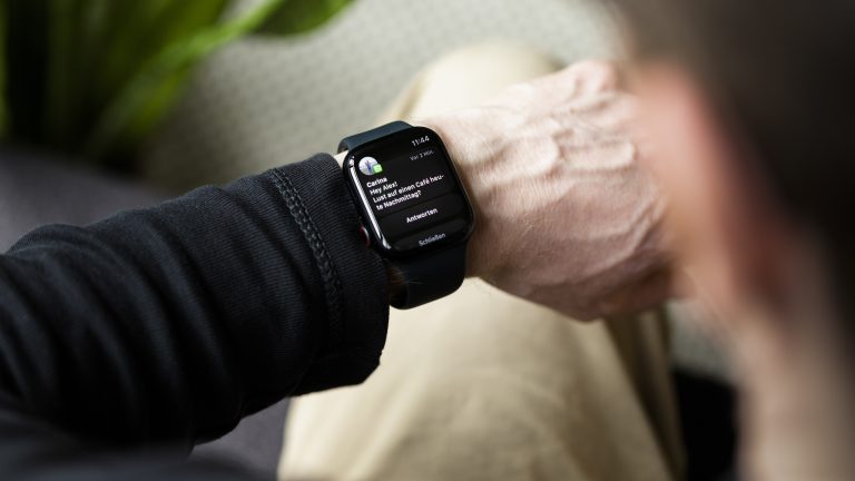 Eine Person schaut auf ihre Apple Watch. Diese zeigt eine gerade eingegangene WhatsApp-Nachricht an.