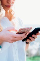 Eine Person hält zwei Smartphones in den Händen.