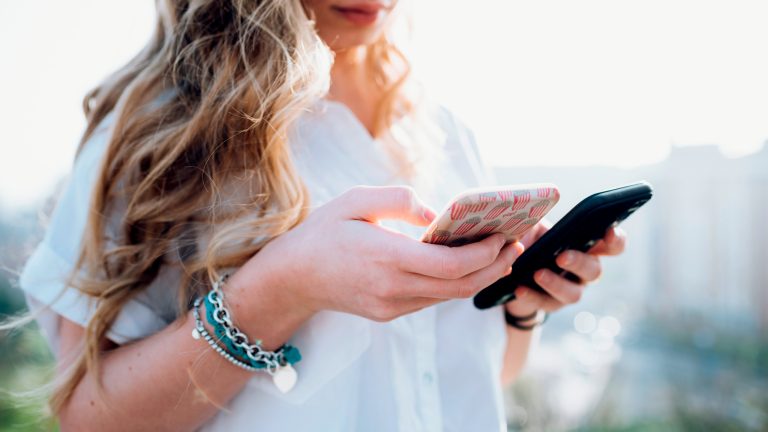 Eine Person hält zwei Smartphones in den Händen.