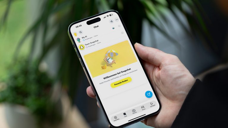 Eine Person hält ein iPhone 14 Pro Max in der Hand, auf dem die Chats von Snapchat zu sehen sind. MyAI steht dabei ganz oben. Eine Person hält ein iPhone 14 Pro Max in der Hand, auf dem die Chats von Snapchat zu sehen sind. MyAI steht dabei ganz oben.
