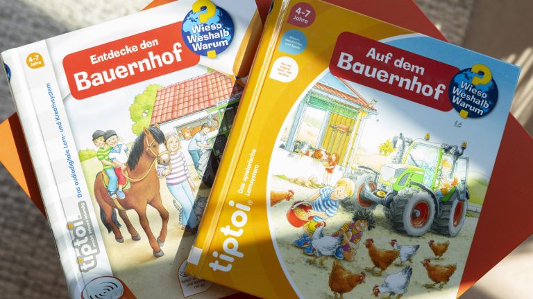 Zwei Tiptoi-Bücher liegen nebeneinander. Zu erkennen ist die farbliche Überarbeitung der Covergestaltung von ehemals Weiß zum aktuellen Orange.