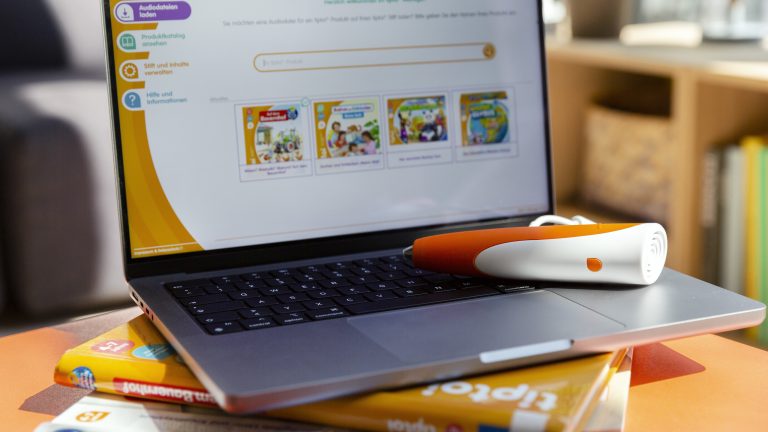 Ein Tiptoi-Stift ist über ein Kabel mit einem Macbook verbunden. Darauf ist der Tiptoi-Manager geöffnet.