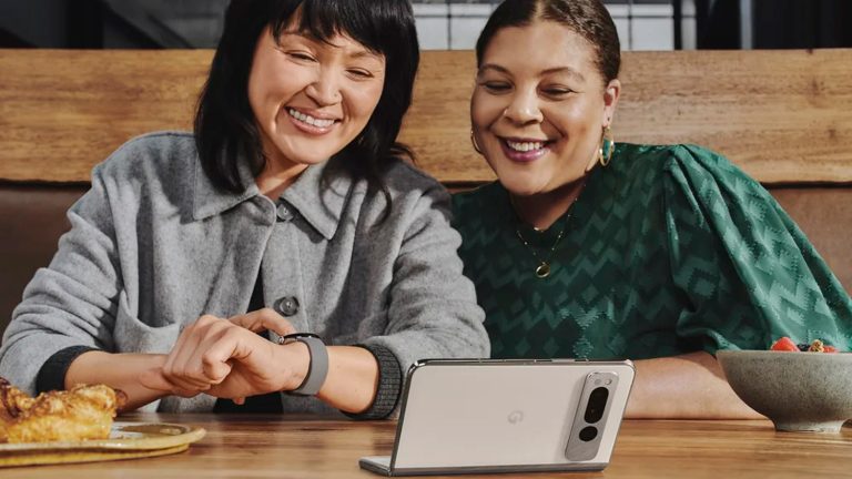 Zwei Personen sitzen vor einem Google Pixel Fold, das halb aufgeklappt ist.