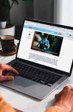 Eine Person sitzt vor einem MacBook und schaut einen Artikel bei UPDATED an.