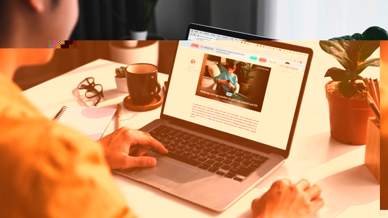 Eine Person sitzt vor einem MacBook und schaut einen Artikel bei UPDATED an.