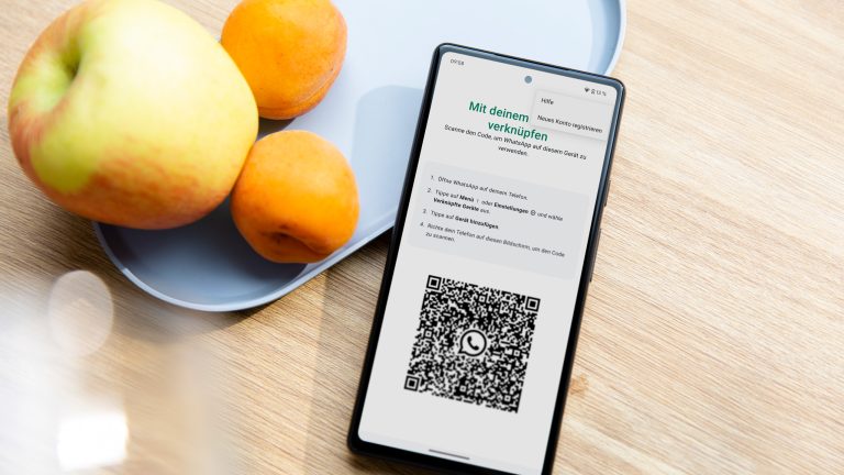 Ein Pixel 6a lehnt an einer Obstschale. AUf dem Display ist der Einrichtungsprozess für WhatsApp zu sehen.