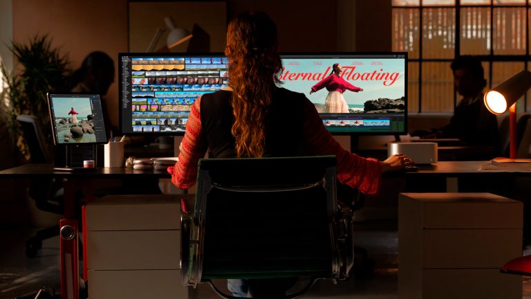 Eine Person sitzt an einem Schreibtisch und arbeitet auf zwei an einen Mac Studio angeschlossenen Monitoren. Eine Person sitzt an einem Schreibtisch und arbeitet auf zwei an einen Mac Studio angeschlossenen Monitoren.
