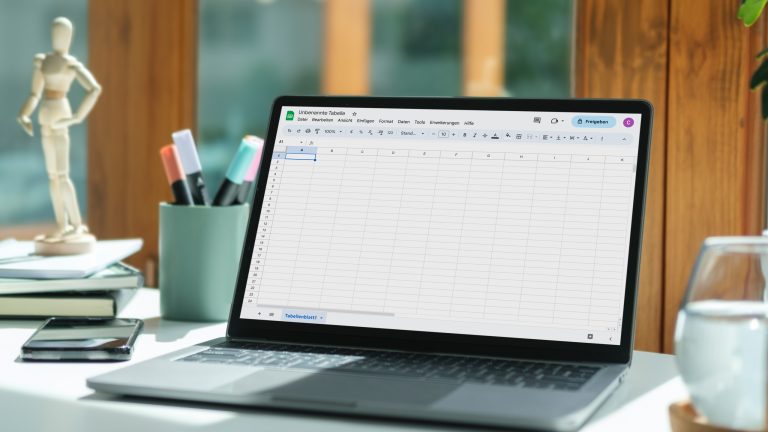 Ein MacBook steht auf einem Tisch. Darauf ist Google Tabellen zu sehen.