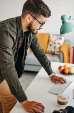 Eine Person stützt die Hände auf einen Schreibtisch, auf dem ein Mac steht.