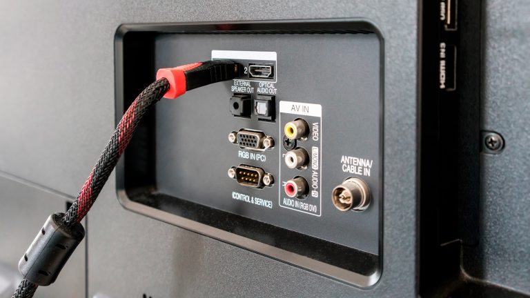 Detailansicht einer TV-Rückseite, in die ein HDMI-Kabel eingesteckt ist.