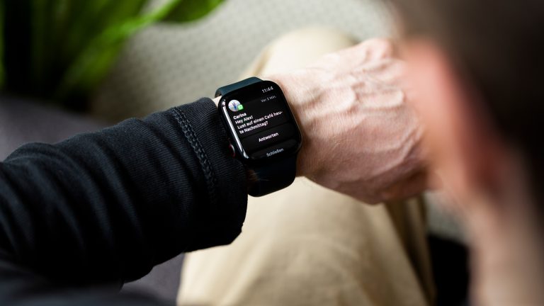 Eine Person schaut auf ihre Apple Watch, auf der gerade eine eingegangene Nachricht angezeigt wird. Eine Person schaut auf ihre Apple Watch, auf der gerade eine eingegangene Nachricht angezeigt wird.