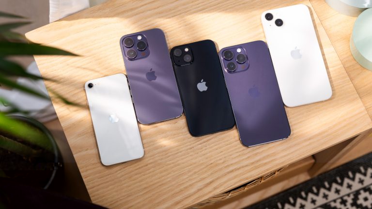 Mehrere iPhone-Modelle liegen auf einem Tisch nebeneinander. Mehrere iPhone-Modelle liegen auf einem Tisch nebeneinander.