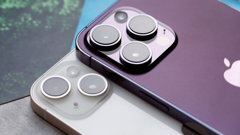 Zwei iPhones liegen übereinander auf einem Tisch.