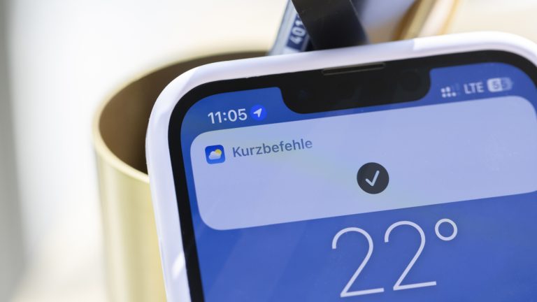 Nahaufnahme eines iPhone 13, auf dem gerade eine Benachrichtigung der Kurzbefehle-App eingeblendet ist.