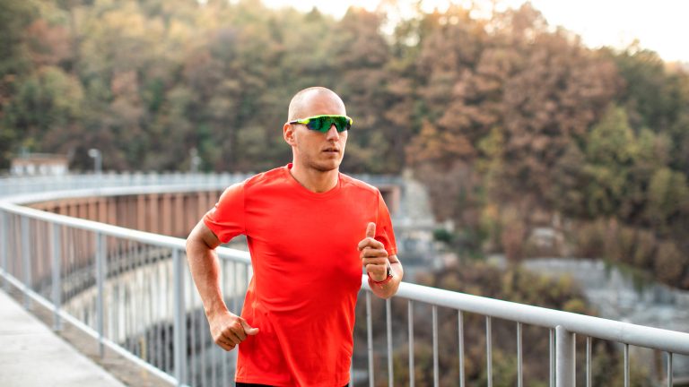 Eine Person joggt über eine Brücke.