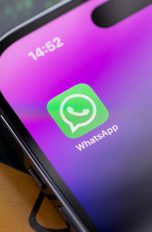 Nahaufnahme eines iPhone 14 Pro, auf dessen Homescreen die WhatsApp-App zu sehen ist.