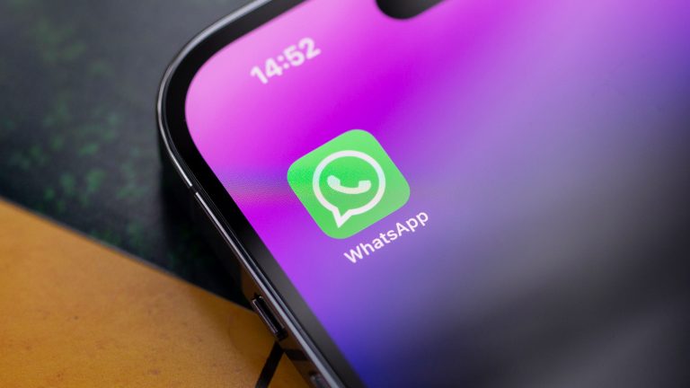 Nahaufnahme eines iPhone 14 Pro, auf dessen Homescreen die WhatsApp-App zu sehen ist.
