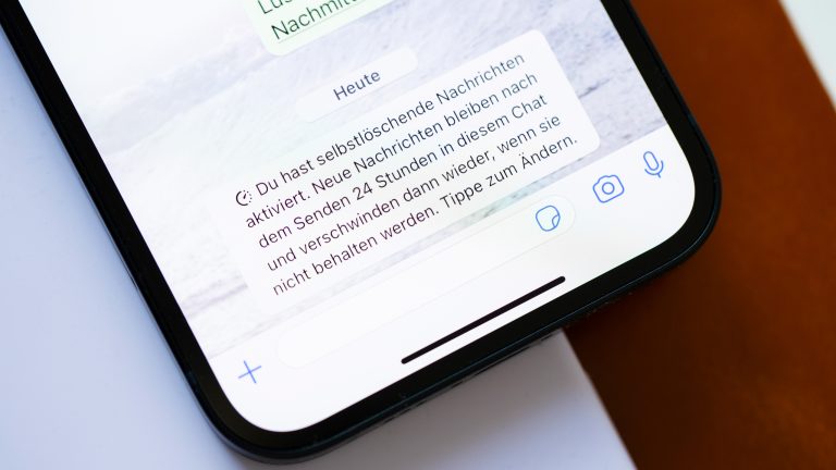 Nahaufnahme eines iPhone 13, auf dem bei WhatsApp in einem Chat selbstlöschende Nachrichten aktiviert sind.