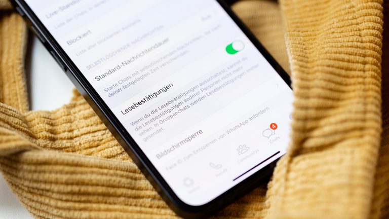 Nahaufnahme eines iPhone 13, auf dem die WhatsApp-Einstellungen geöffnet und die Lesebestätigungen aktiviert sind.