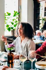 Mehrere Personen sitzen in einem Restaurant an einem Tisch und essen.
