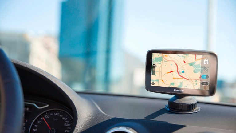 Ein TomTom-Navi ist in der Nahaufnahme auf dem Dashboard eines Autos zu sehen.