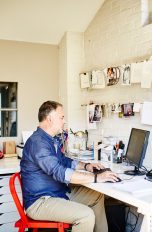 Eine Person sitzt in einem Büro an einem Schreibtisch und tippt auf einer Tastatur.