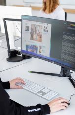 Eine Person sitzt in einem Büro vor einem Ultrawide-Monitor.