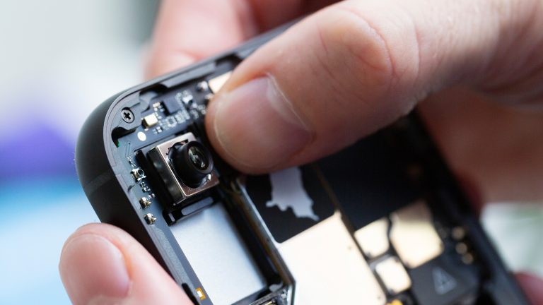 Eine Person setzt das Kamera-Modul des Fairphone 5 ins Gehäuse. Eine Person setzt das Kamera-Modul des Fairphone 5 ins Gehäuse.