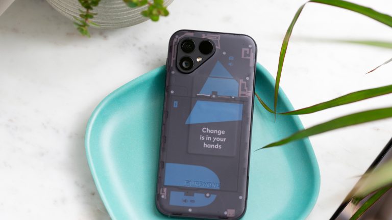 Ein Fairphone 5 mit transparenter Rückseite liegt in einer Deko-Schale. Ein Fairphone 5 mit transparenter Rückseite liegt in einer Deko-Schale.