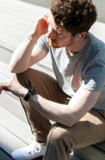 Eine Person mit einer Apple Watch am Arm telefoniert über verbundene AirPods.