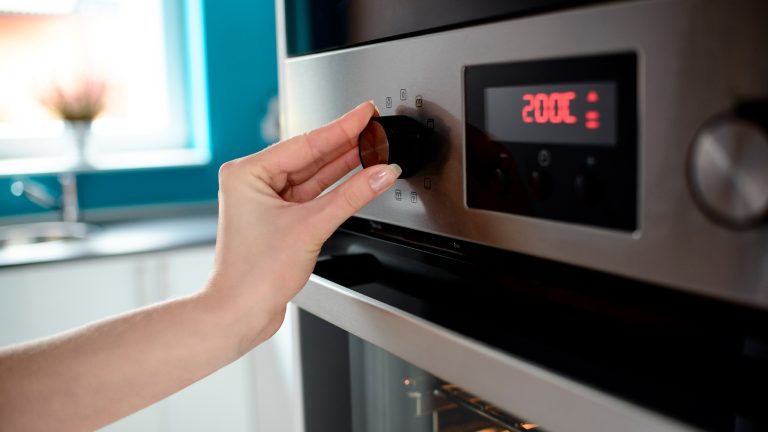 Eine Person dreht an einem Knopf, der an einem Pyrolyse-Backofen angebracht ist.