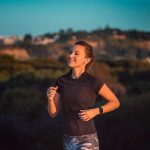 Eine Person joggt im Freien. Am linken Arm trägt sie eine Laufuhr.