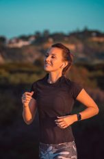 Eine Person joggt im Freien. Am linken Arm trägt sie eine Laufuhr.