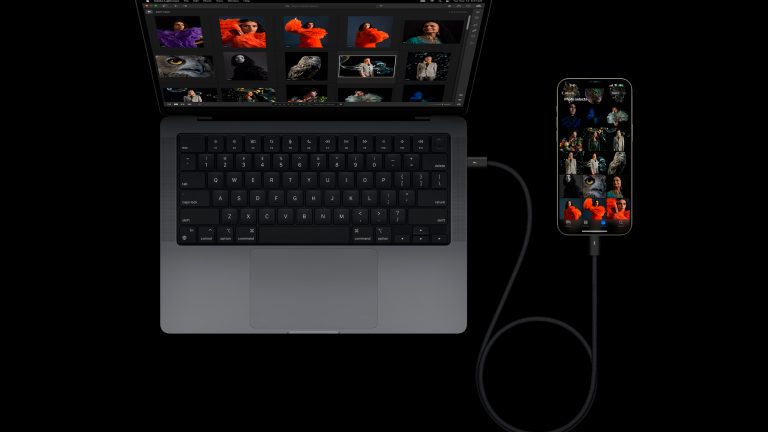 Produktbild eines iPhone 15 Pro, das per USB-C-Kabel mit einem MacBook verbunden ist. Produktbild eines iPhone 15 Pro, das per USB-C-Kabel mit einem MacBook verbunden ist.