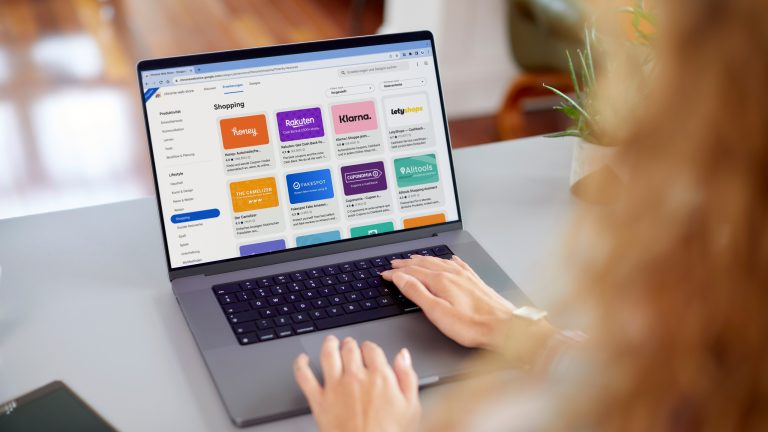 Eine Person sitzt vor einem Schreibtisch am Laptop und sieht sich Erweiterungen der Kategorie Shopping für den Google Chrome Browser an.