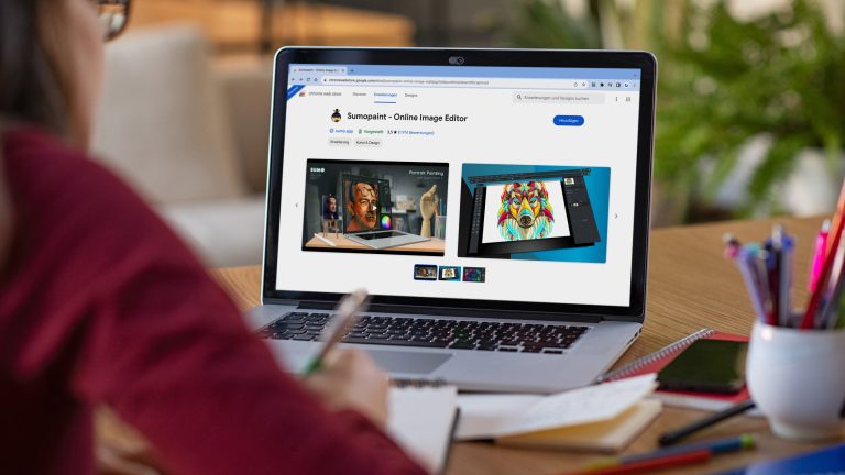 Bildbearbeitung geht heutzutage auch bequem im Browser – mit Sumopaint. Eine Person sitzt am Schreibtisch vor einem Laptop und notiert sich etwas mit einem Stift auf einen Block. Auf dem Bildschirm ist die Google Chrome Erweiterung Sumopaint zu sehen.