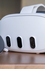 Eine Meta Quest 3 mitsamt einem Controller liegt auf einem Holztisch.