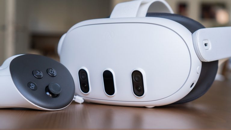 Eine Meta Quest 3 mitsamt einem Controller liegt auf einem Holztisch.