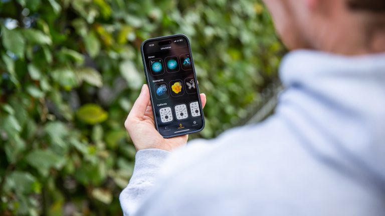 Eine Person ändert das Zifferblatt einer Apple Watch über das damit gekoppelte iPhone.