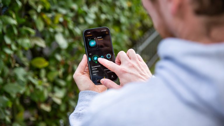 Eine Person passt die Details eines Zifferblatts der Apple Watch über das verbundene iPhone an.