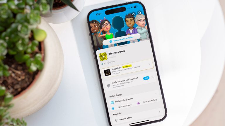 Ein Smartphone liegt auf einem Tisch. Darauf ist ein Snapchat-Profil zu sehen.