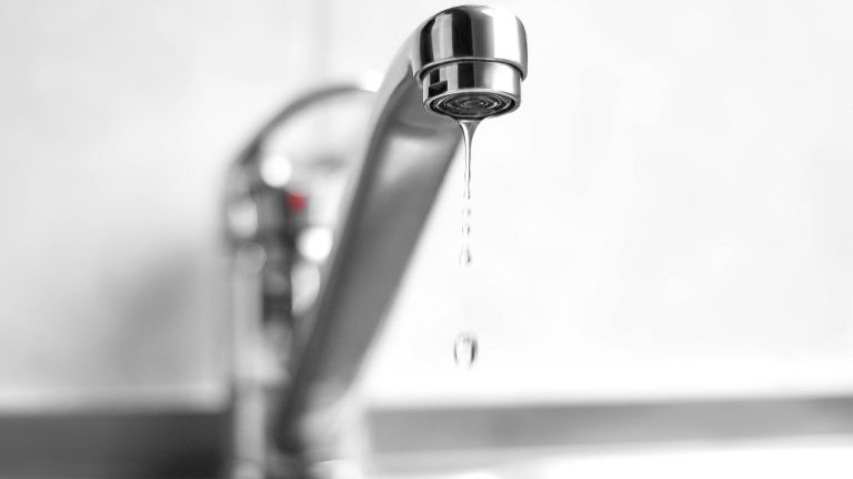 Blick auf einen Wasserhahn, aus dem Wasser tropft.