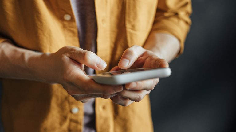 Eine Person tippt auf einem Smartphone.