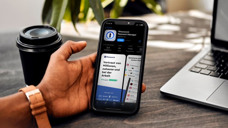 Von Smartphone bis Laptop: 1Password ist einer der beliebtesten Manager. Ein Mann hält ein iPhone. Auf dem Bildschirm ist die 1Password-App im Apple App Store geöffnet.