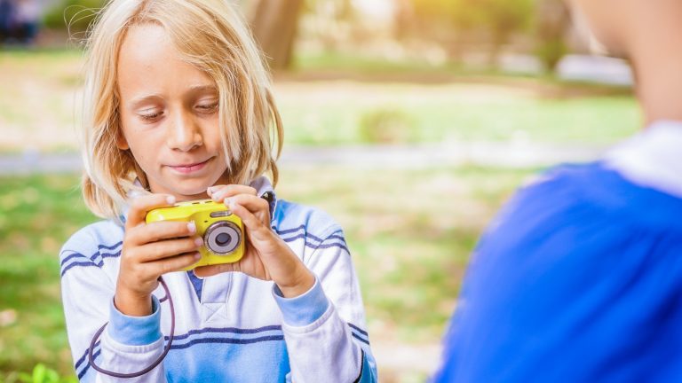 Ein Kind bedient eine Kinderkamera.