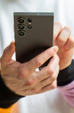 Eine Person hält ein Smartphone in der Hand.
