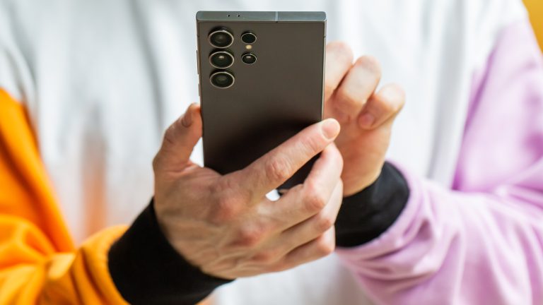 Eine Person hält ein Smartphone in der Hand.