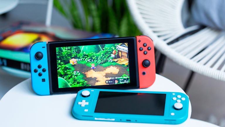 Eine Nintendo Switch und eine Nintendo Switch Lite auf einem kleinen Tisch.