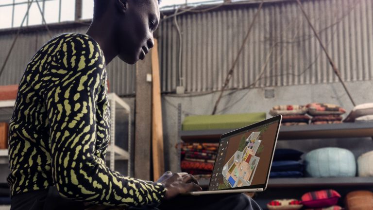 Eine Person arbeitet an einem MacBook Air, das sie auf den Knien abgelegt hat. Eine Person arbeitet an einem MacBook Air, das sie auf den Knien abgelegt hat.